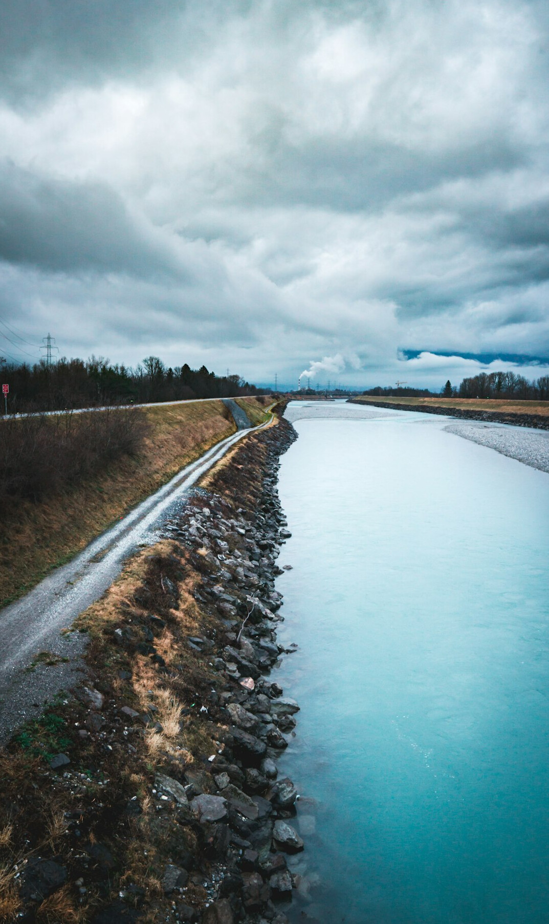 Industrial pipes discharging into a Swiss river under an overcast sky